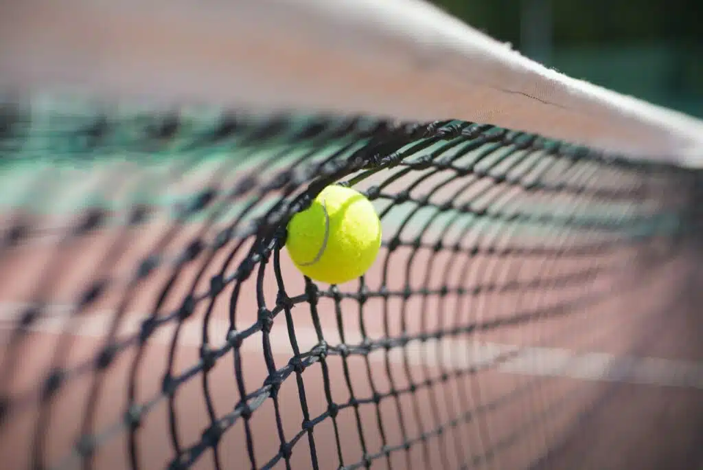 Tennis ball hits in the net during game.