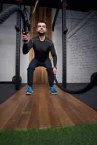 Man doing exercise with fitness rope in gym