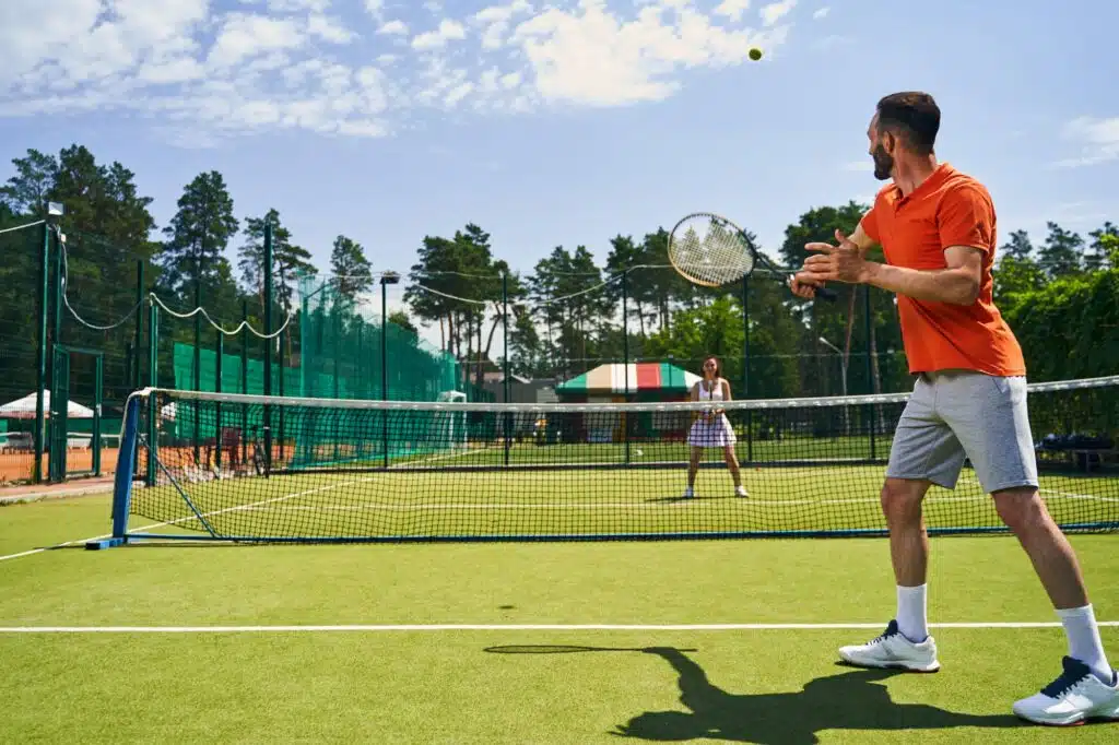 Man playing a singles match with his tennis partner