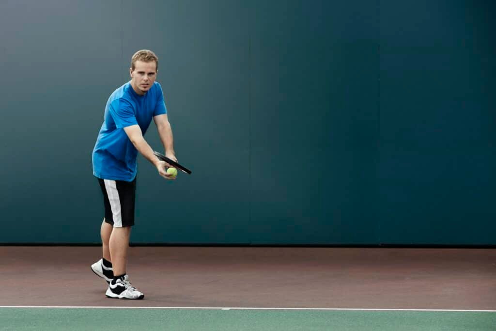 Tennis player about to serve ball in tennis court