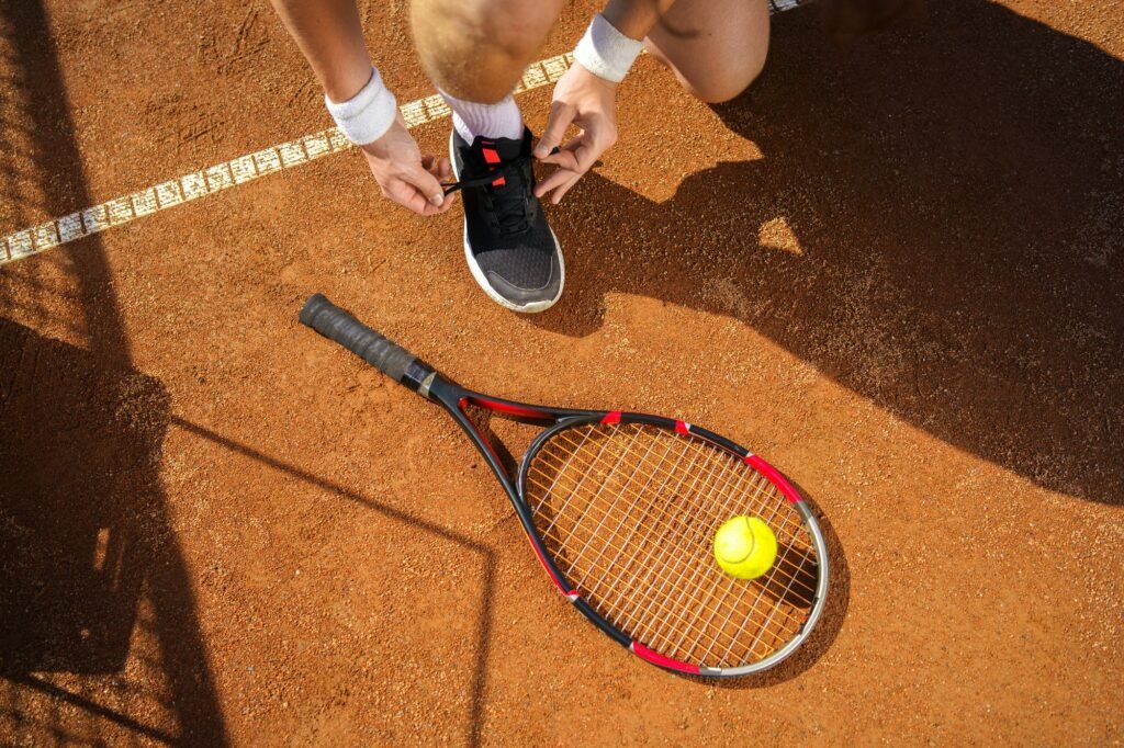 Tennis player tying his shoes