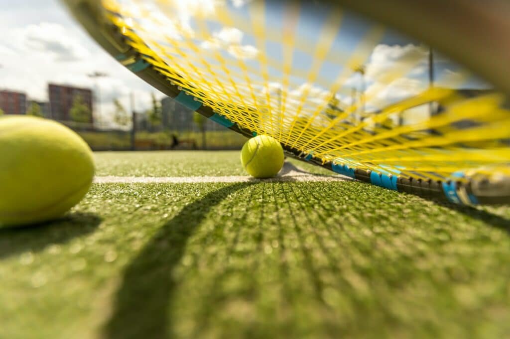 tennis racket with a tennis ball on a tennis court