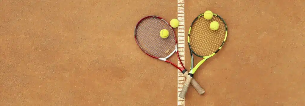 Tennis racquets with tennis balls on clay court