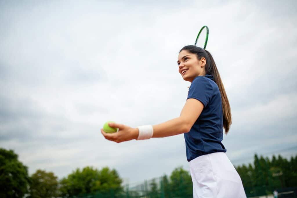 Young handsome tennis player with racket and ball prepares to serve at beginning of game or match.